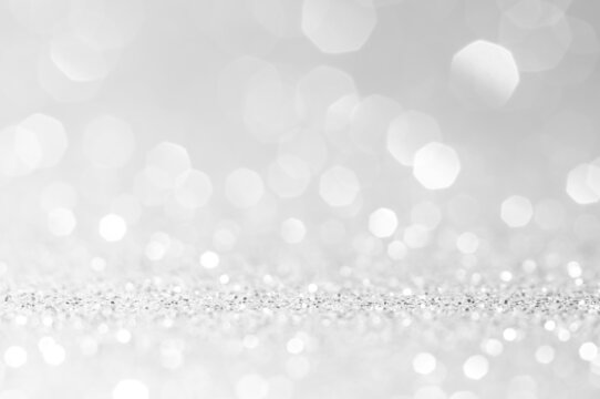 Abstract bokeh white,light grey,sliver colors de focused circular background.Night light season greeting elegance backdrop or artwork design for newyear,christmas sparkling glittering or special day.