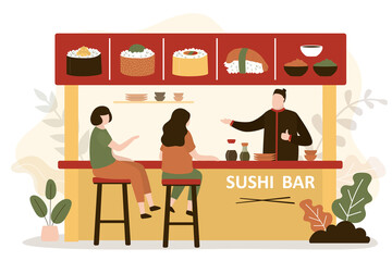 Girls came to eat traditional japanese food in cafe. Chef prepares various sushi and rolls for visitors