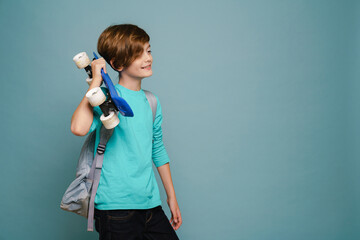 Ginger white boy smiling while posing with skateboard