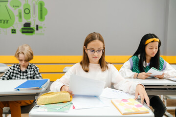 Multiracial pupils studying together during class
