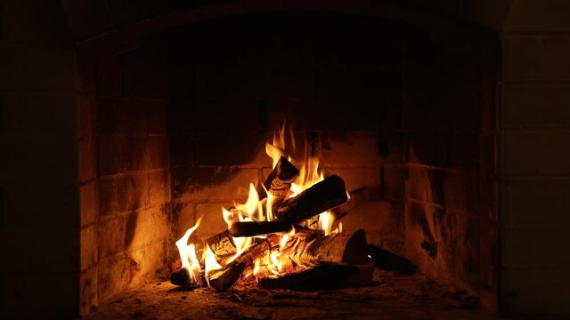 A Looping Clip of a Fireplace with Medium Size Flames Burning Fire. Warm Cozy Fireplace with Real Wood Burning in it Winter and Christmas Holidays Concept