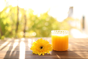 Mango juice glass cup and yellow gerbera flower