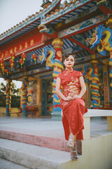 Fototapeta premium Beautiful Asian Chinese Woman Wearing Cheongsam Traditional Red Dress Fashion Posting Chinese Lunar New Year.