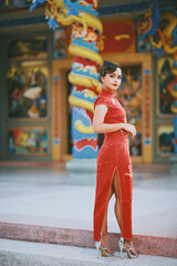 Obraz na płótnie Canvas Beautiful Asian Chinese Woman Wearing Cheongsam Traditional Red Dress Fashion Posting Chinese Lunar New Year.