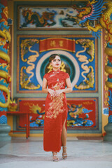 Fototapeta premium Beautiful Asian Chinese Woman Wearing Cheongsam Traditional Red Dress Fashion Posting Chinese Lunar New Year.