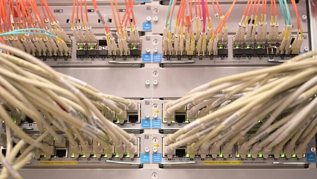 LED Leuchten an einem Netzwerk Switch mit RJ45 und Lichtwellenkabel in einem Rechenzentrum