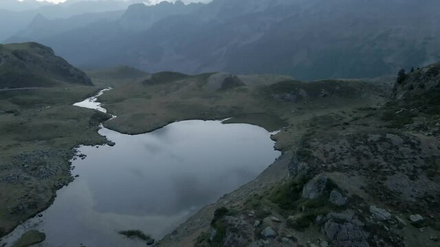 Bird's eye view over the receding water level of lake Ayous during autumn season in the Pyrenees in France after sunset.
