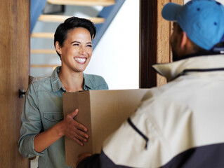 It got here so fast. Shot of a smiling young woman standing at her front door receiving a package...