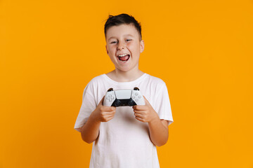Brunette white boy smiling while playing online game with joystick © Drobot Dean