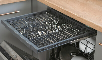 Dishwasher close-up with washed dishes, easy to use and save water, eco-friendly, built-in kitchen...