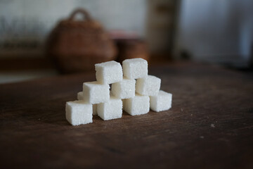 Sugar in cubes scattered on the kitchen board