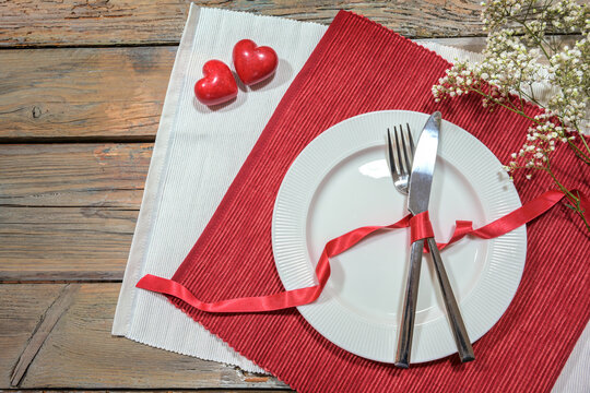 Table Setting For A Romantic Dinner With Two Hearts, Pate And Cutlery On Red And White Napkins, Love Concept, Rustic Wooden Table With Copy Space, High Angle View From Above