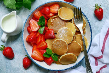 Hot delicious pancakes with fresh strawberry for a breakfast. Top view with copy space.
