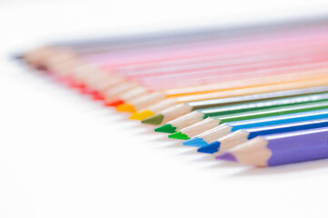 Set of wooden colored pencils- crayons on a white paper.