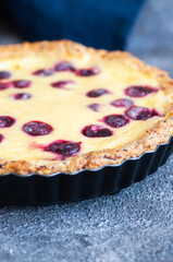 Homemade ricotta cheese pie with cherries on a gray background. Close up. Hearty baking.