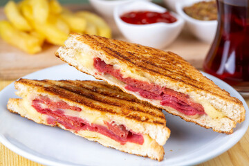 Turkish toast, mixed toast with cheddar cheese, sausage and ham, with fried potatoes (Turkish name; Karisik tost)
