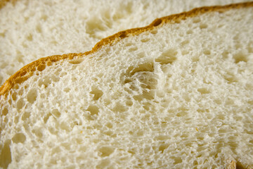Close up of slice of freshly baked wheat bread, perspective view selective focus. Food background with texture of bread.