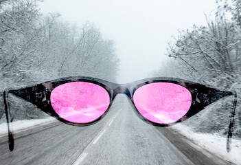 Blick durch eine rosa Brille auf einer gefahrvollen Strasse