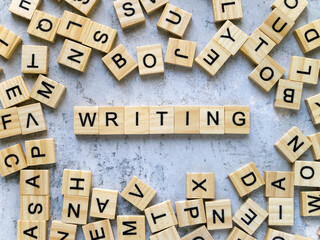 Top view of the word WRITING. Wooden letters add up to words.