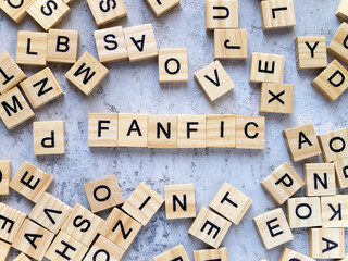 Top view of the word FANFIC. Wooden letters add up to words.