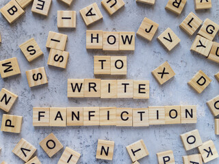 Top view of words HOW TO WRITE FANFICTION made from wooden letters. The concept of writing skills.