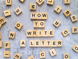 Top view of words HOW TO WRITE A LETTER made from wooden letters. The concept of writing skills.