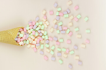 Food background. Wafer horn and marshmallow on a pastel background, top view, flat lay, minimalist trend.
