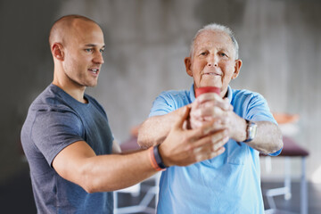 You say senior, I say strong. Shot of a senior man working out with the help of a trainer.