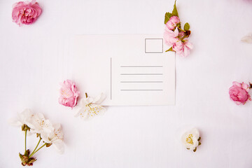 Spring festive post card mock up with pink and white flowers. Invitation, romantic, wedding, birthday, Woman's day, Mother's day card concept. Copy space. View from above