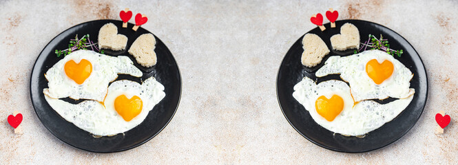 Valentine's day egg breakfast on the table scrambled fried eggs heart shape love holiday decoration date copy space food background