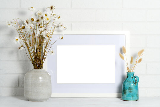 Empty picture frame with beautiful bouquets