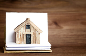 Obraz na płótnie Canvas Miniature wooden house standing on a small open book