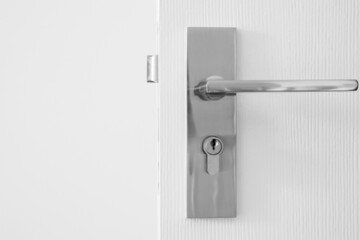 Modern door handle with keyhole on white door