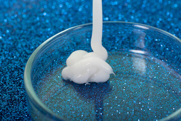 Closeup photography of white cream dripping in petri dish.