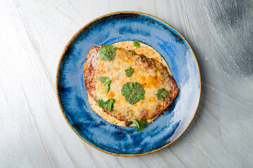 Vienna schnitzel from veal in sauce on grey table top view
