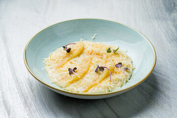 mashed potatoes with parmesan and dor blue on blue plate on grey table