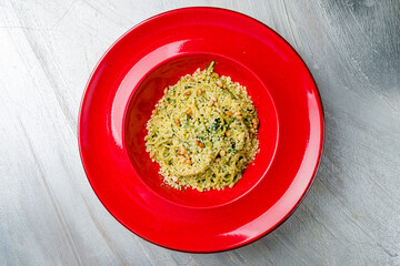spaghetti with spinach, parmesan and cashew nuts on grey table top view