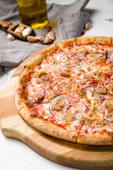 Pizza with tuna and red onion on the board on grey table macro close up