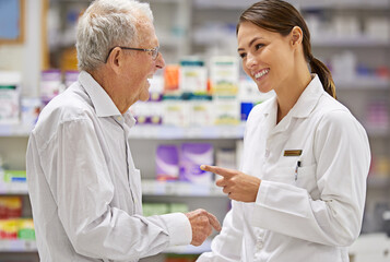 Obraz premium Treating her clients with care. Shot of a young pharmacist helping an elderly customer.
