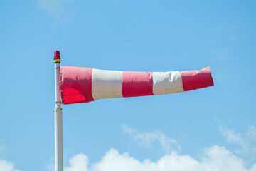 Windsock against a blue sky and clouds showed the wind direction.