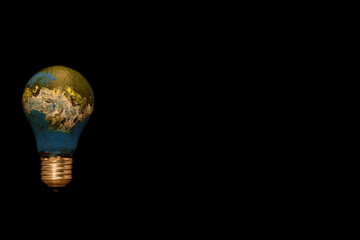 Planet Earth as a light bulb. Ecological concept of energy. Isolated on a black background. 