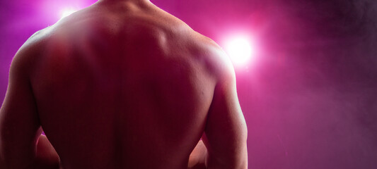 Hombre musculoso de espalda a la cámara Espalda musculosa desnuda a contraluz. Iluminación...