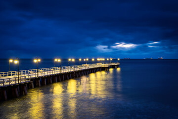Fototapeta na wymiar Winter pier by the Baltic Sea in Gdynia Orlowo at dawn. Poland