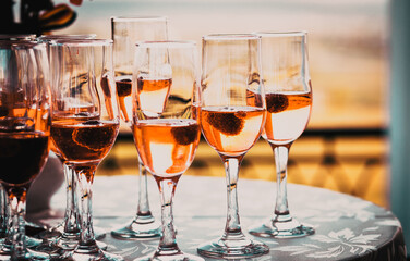 champagne glasses on a table at sunset