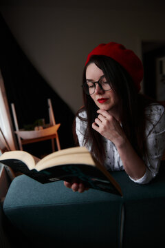 a girl with dark long hair in a red beret and a white blouse, retro style. Indoor soft light