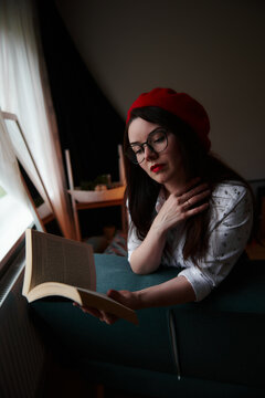 a girl with dark long hair in a red beret and a white blouse, retro style. Indoor soft light