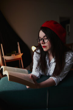 a girl with dark long hair in a red beret and a white blouse, retro style. Indoor soft light