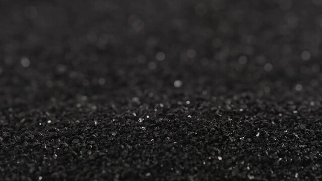 pouring black coconut charcoal close-up slo-mo, activated carbon small fraction