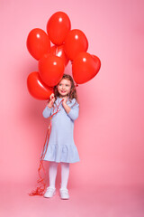 Obraz na płótnie Canvas Beautiful child girl with red heart romantic balloons on pink background. Concept of Valentine day