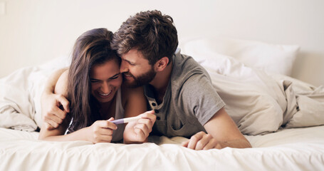 We're going to make great parents. Shot of a happy young couple taking a pregnancy test at home.